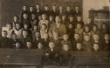 Řídící učitel Jaroslav Špinar s žáky ve staré škole. (1926)